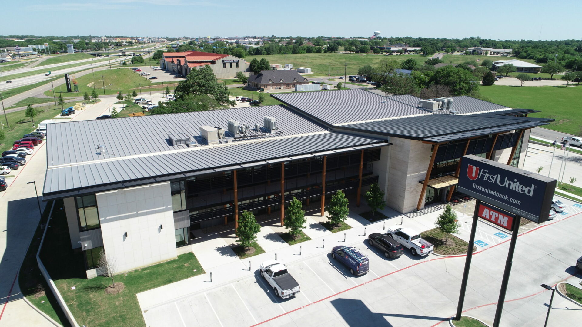 Dark standing seam metal roof on a commercial bank building